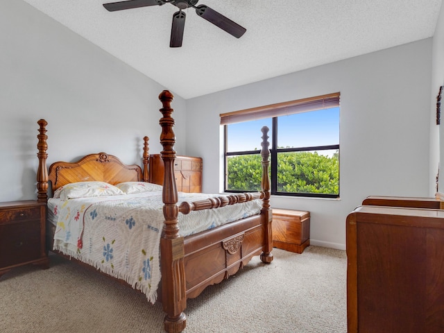 bedroom featuring ceiling fan, a textured ceiling, light carpet, baseboards, and vaulted ceiling