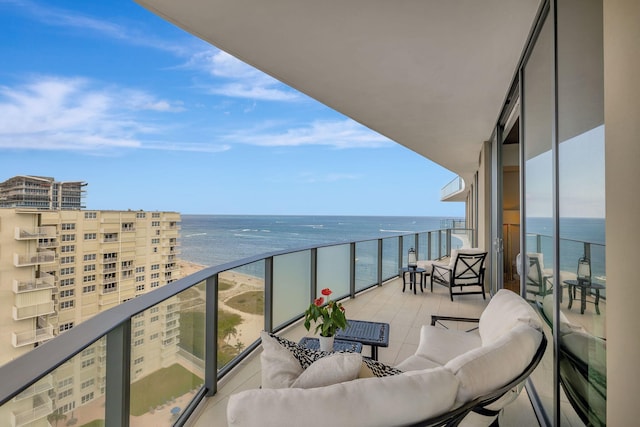 balcony with an outdoor living space and a water view