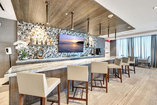 bar with light stone countertops and wooden ceiling