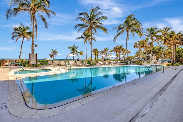 view of pool with a patio and a hot tub