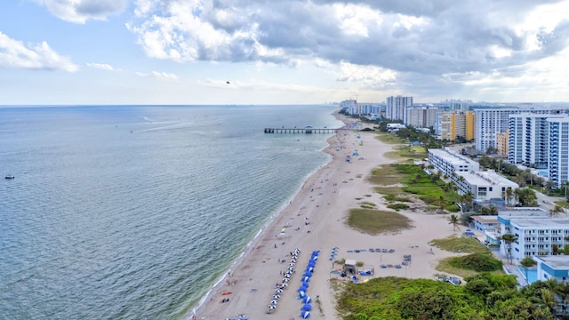 birds eye view of property with a water view and a beach view