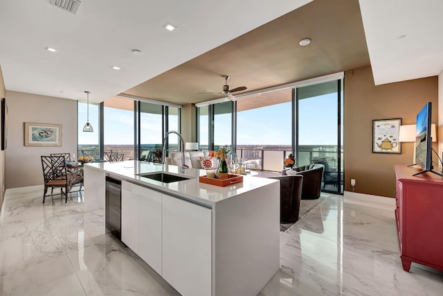 kitchen featuring a center island with sink, a healthy amount of sunlight, white cabinetry, and sink