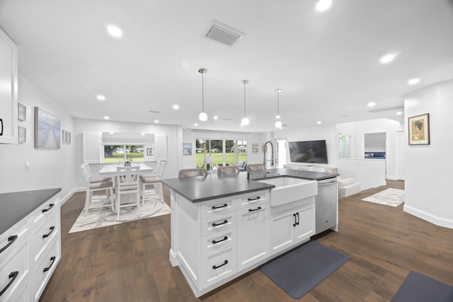 kitchen with a kitchen island with sink, dark wood-type flooring, white cabinets, sink, and decorative light fixtures