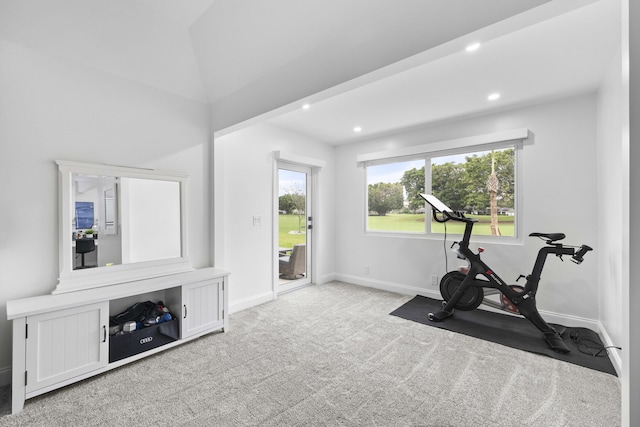 workout room with light carpet and lofted ceiling