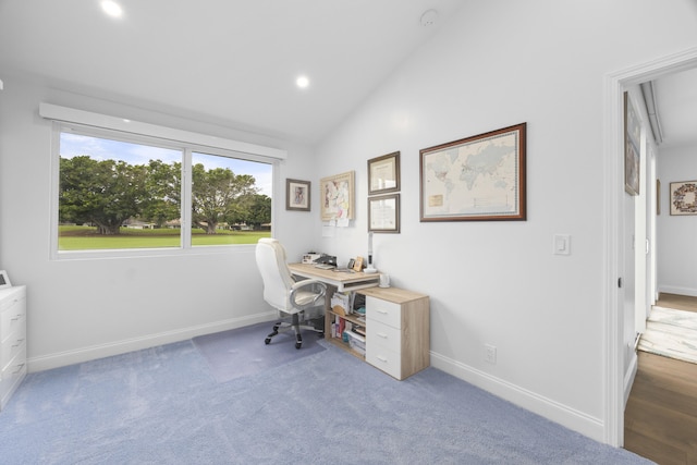 carpeted office space featuring vaulted ceiling