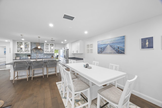 dining space with dark hardwood / wood-style flooring and sink