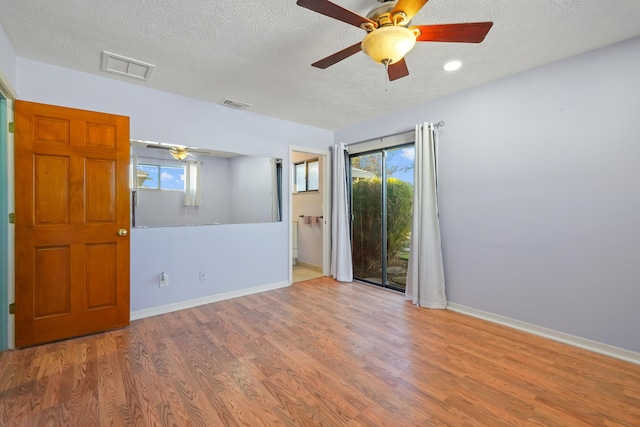 unfurnished room with ceiling fan, plenty of natural light, light hardwood / wood-style flooring, and a textured ceiling