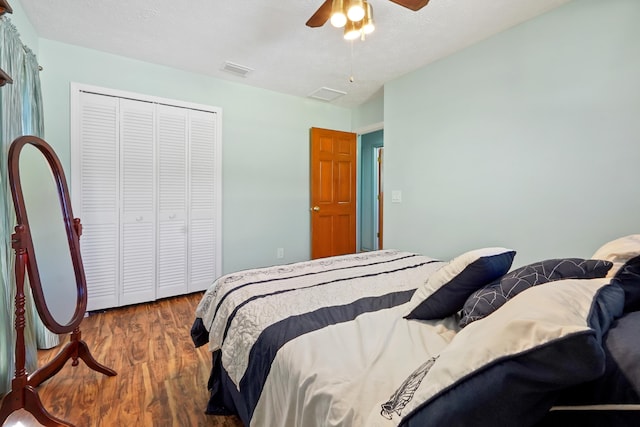 bedroom featuring ceiling fan, hardwood / wood-style floors, a closet, and a textured ceiling