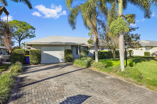 ranch-style house with a garage and a front lawn