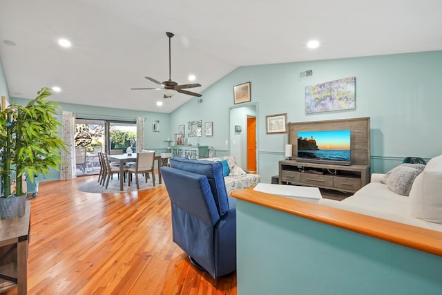 living room with wood-type flooring, lofted ceiling, and ceiling fan