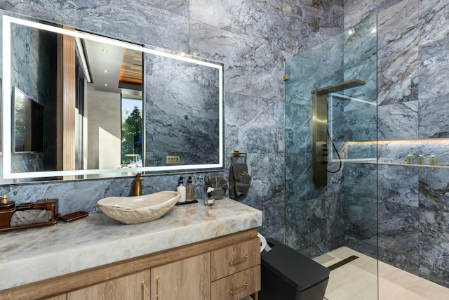 bathroom featuring a tile shower, vanity, and tile walls