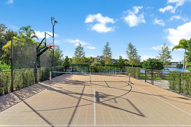 view of basketball court featuring tennis court and a water view