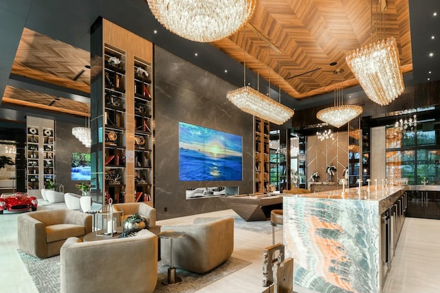 bar featuring decorative light fixtures, light stone counters, a high ceiling, and an inviting chandelier