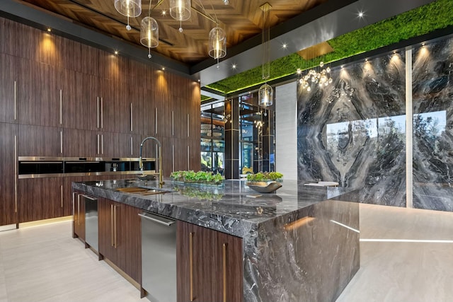 interior space with decorative light fixtures, dark stone counters, and sink