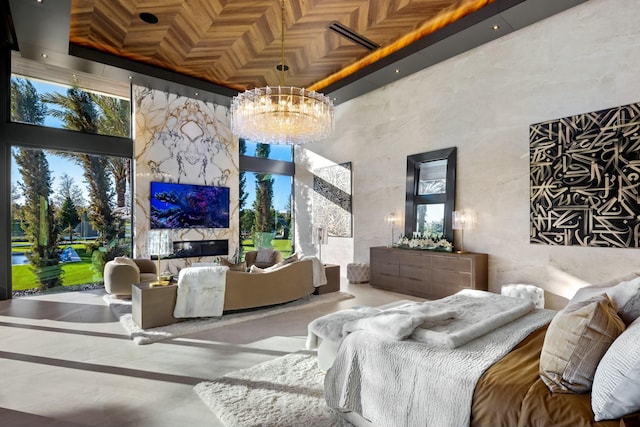 bedroom with a high ceiling, multiple windows, and a notable chandelier