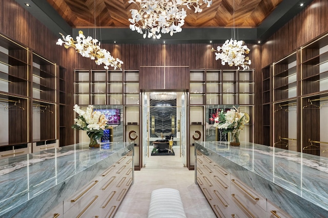 spacious closet featuring a towering ceiling and a chandelier