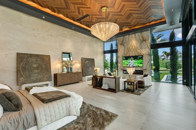 bedroom featuring access to exterior, a chandelier, and a high ceiling