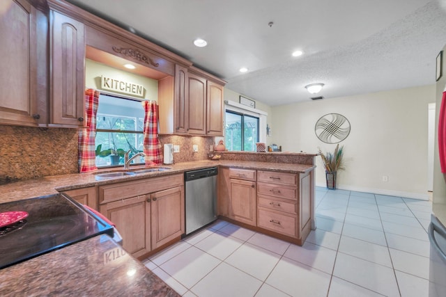 kitchen featuring sink, stainless steel dishwasher, decorative backsplash, a textured ceiling, and kitchen peninsula