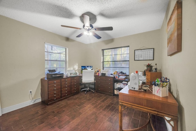 office area with a textured ceiling, ceiling fan, dark wood-type flooring, and a wealth of natural light