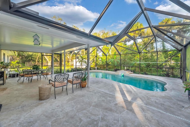 view of pool with glass enclosure and a patio area