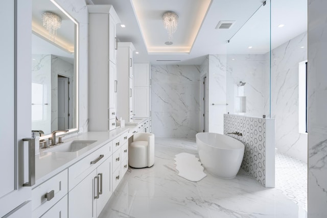 bathroom featuring separate shower and tub, a raised ceiling, vanity, and a chandelier