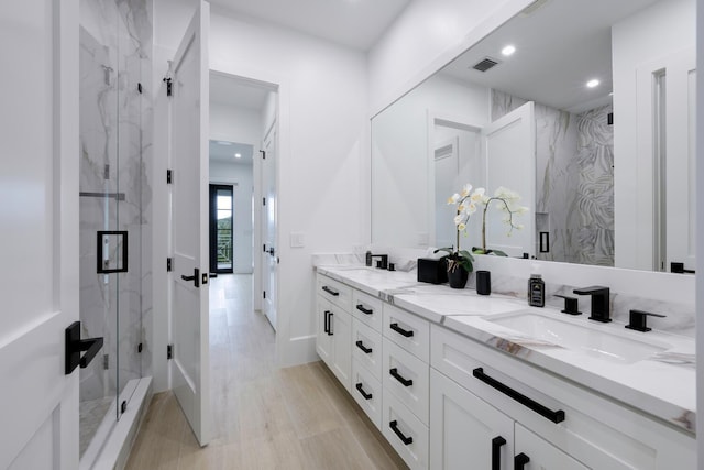 bathroom featuring wood-type flooring, vanity, and a shower with shower door