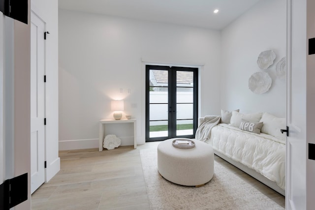 bedroom with access to outside, light hardwood / wood-style flooring, and french doors