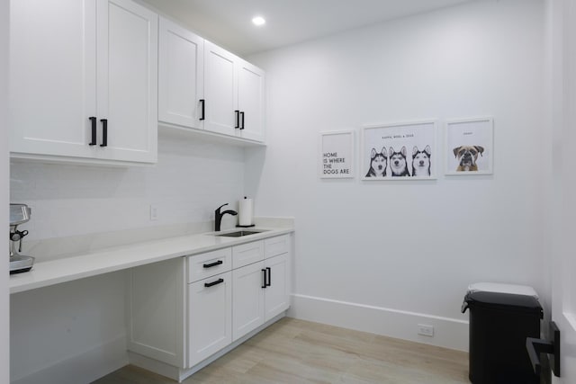 laundry room with sink and light hardwood / wood-style flooring