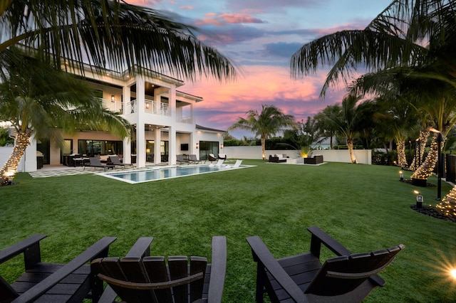 yard at dusk with a balcony and a patio