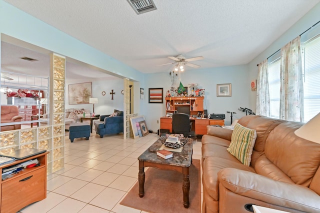 living room with ceiling fan, a textured ceiling, and light tile patterned floors