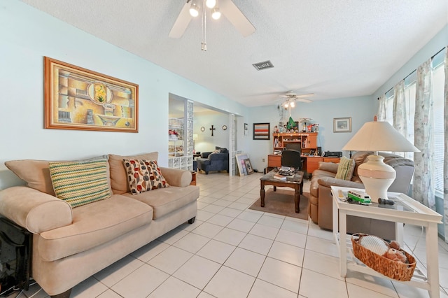 tiled living room featuring ceiling fan and a textured ceiling