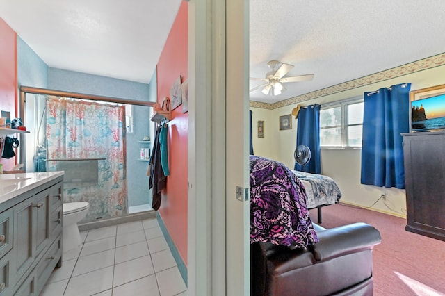 bathroom featuring a textured ceiling, tile patterned floors, vanity, toilet, and ceiling fan