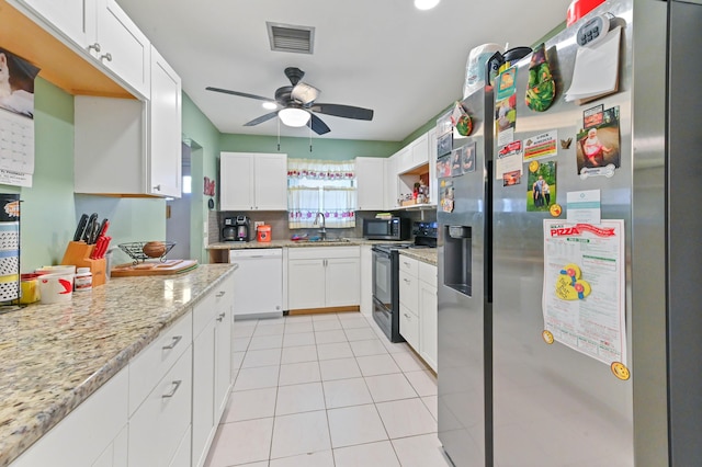 kitchen featuring appliances with stainless steel finishes, white cabinetry, decorative backsplash, sink, and light stone counters