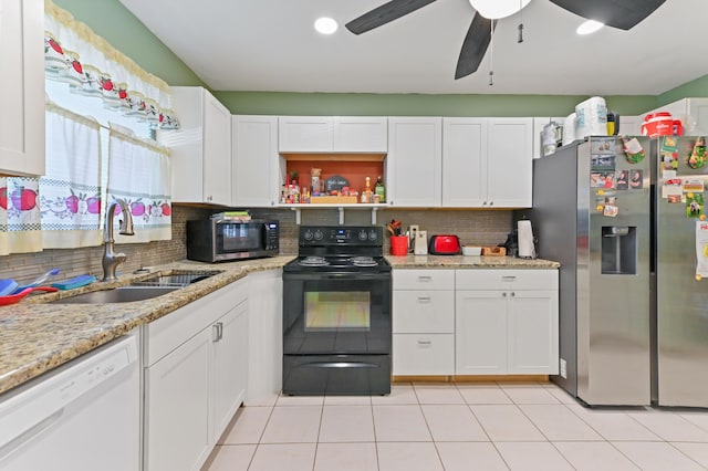 kitchen with white cabinets, stainless steel appliances, decorative backsplash, sink, and light stone counters