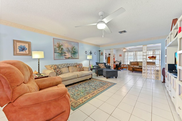 tiled living room with decorative columns, ceiling fan, and a textured ceiling