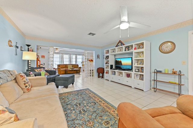 living room with ceiling fan, a textured ceiling, and light tile patterned flooring