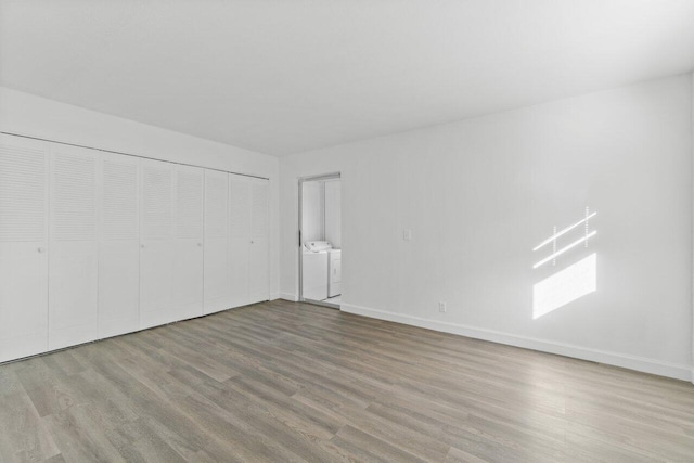 empty room featuring separate washer and dryer and light hardwood / wood-style flooring