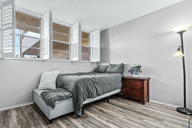 bedroom featuring a textured ceiling and hardwood / wood-style flooring