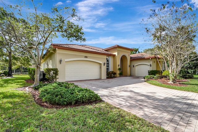 mediterranean / spanish house featuring a garage and a front lawn