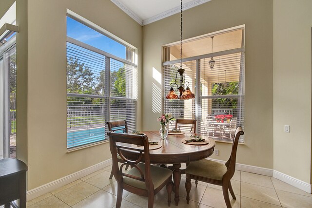 dining area with light tile patterned flooring and ornamental molding