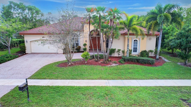 mediterranean / spanish home featuring a front lawn and a garage