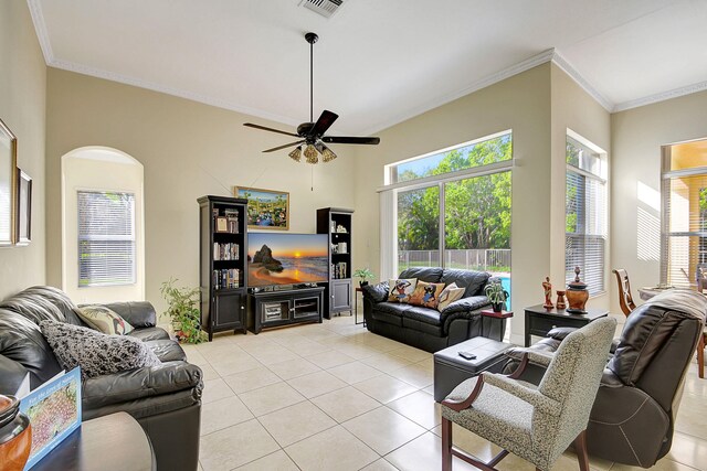 tiled living room featuring a high ceiling, ceiling fan, and crown molding