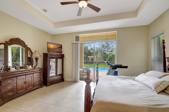 tiled bedroom with multiple windows, access to outside, a raised ceiling, and ceiling fan