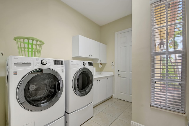 washroom with cabinets, light tile patterned flooring, and washing machine and dryer