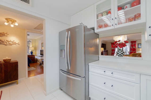 kitchen with white cabinets, a notable chandelier, stainless steel fridge, and light tile patterned flooring