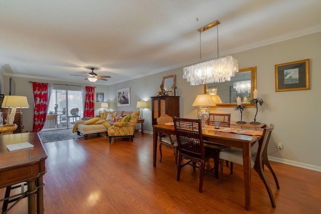 dining room with wood-type flooring, ceiling fan with notable chandelier, and ornamental molding