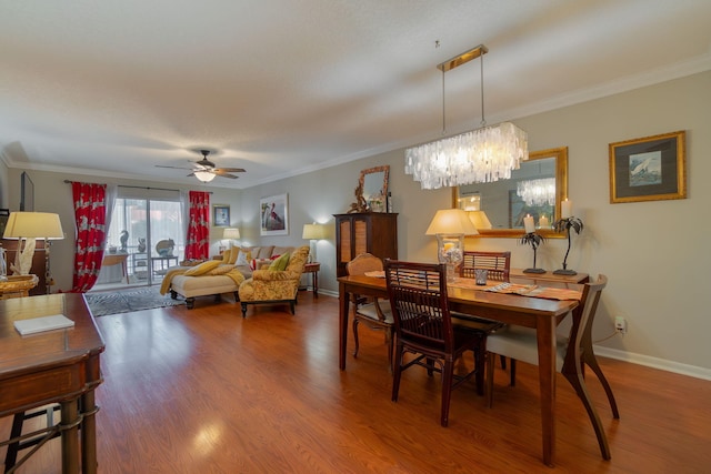 dining room with hardwood / wood-style flooring, ceiling fan with notable chandelier, and ornamental molding