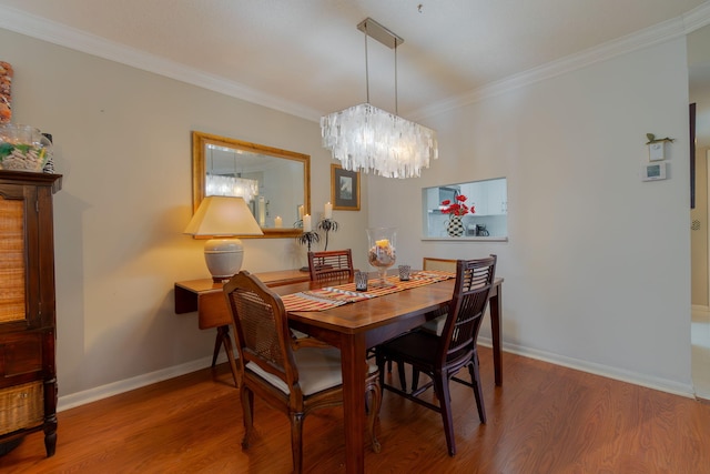 dining space featuring hardwood / wood-style floors, a notable chandelier, and crown molding