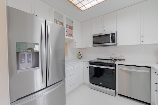 kitchen featuring light tile patterned floors, stainless steel appliances, and white cabinetry