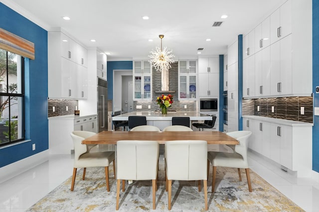 dining room featuring crown molding, an inviting chandelier, and light tile patterned floors